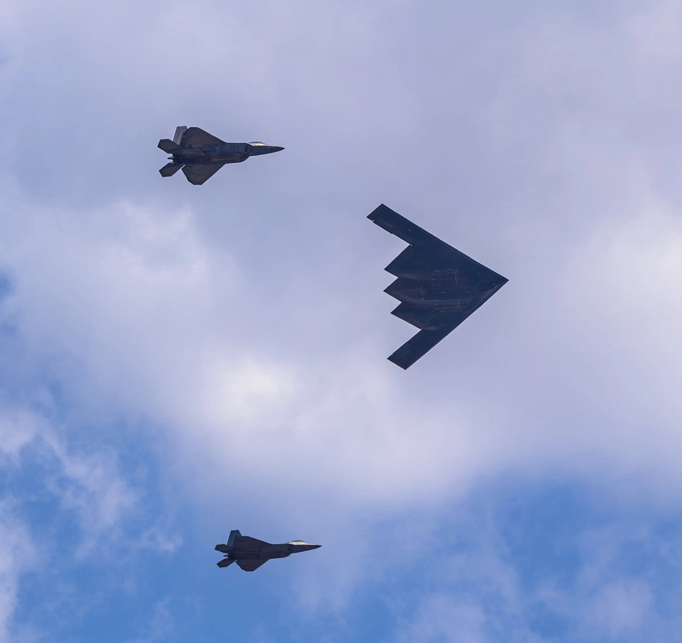 F-35 Lightning II fighters fly alongside a B-2 Spirit stealth bomber in a dramatic military formation over Washington, D.C.