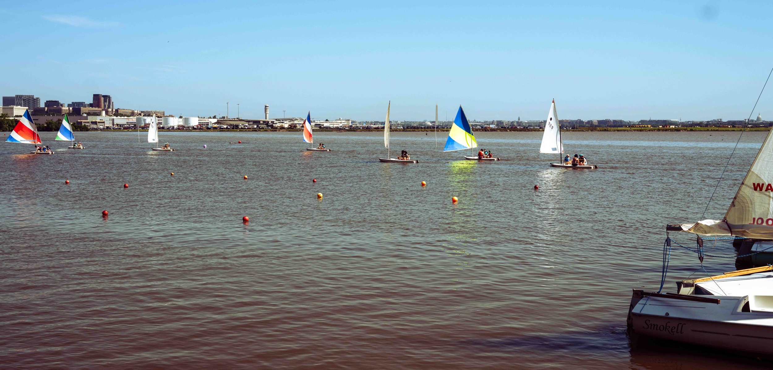Sailing instruction unfolds against a backdrop of Washington, D.C.'s historic monuments and waterfront.