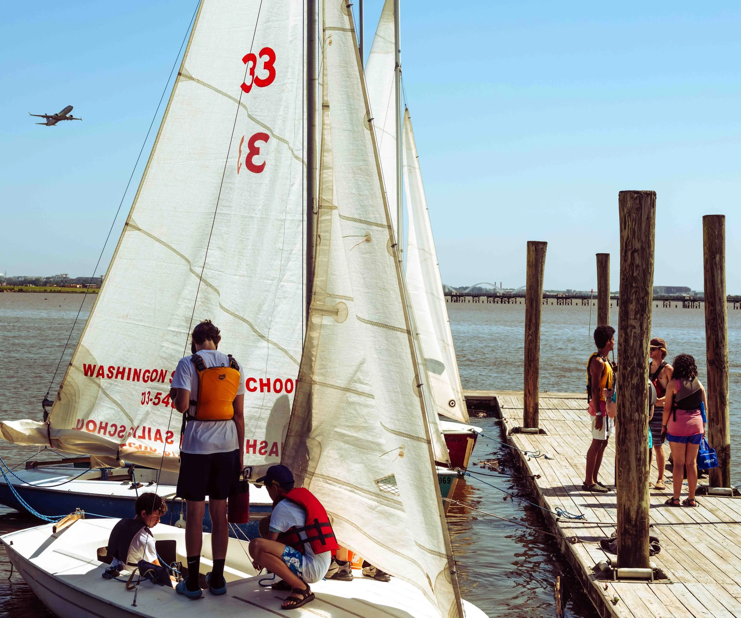 Students prepare a training sailboat at the dock during a Washington Sailing School lesson on the Potomac River.