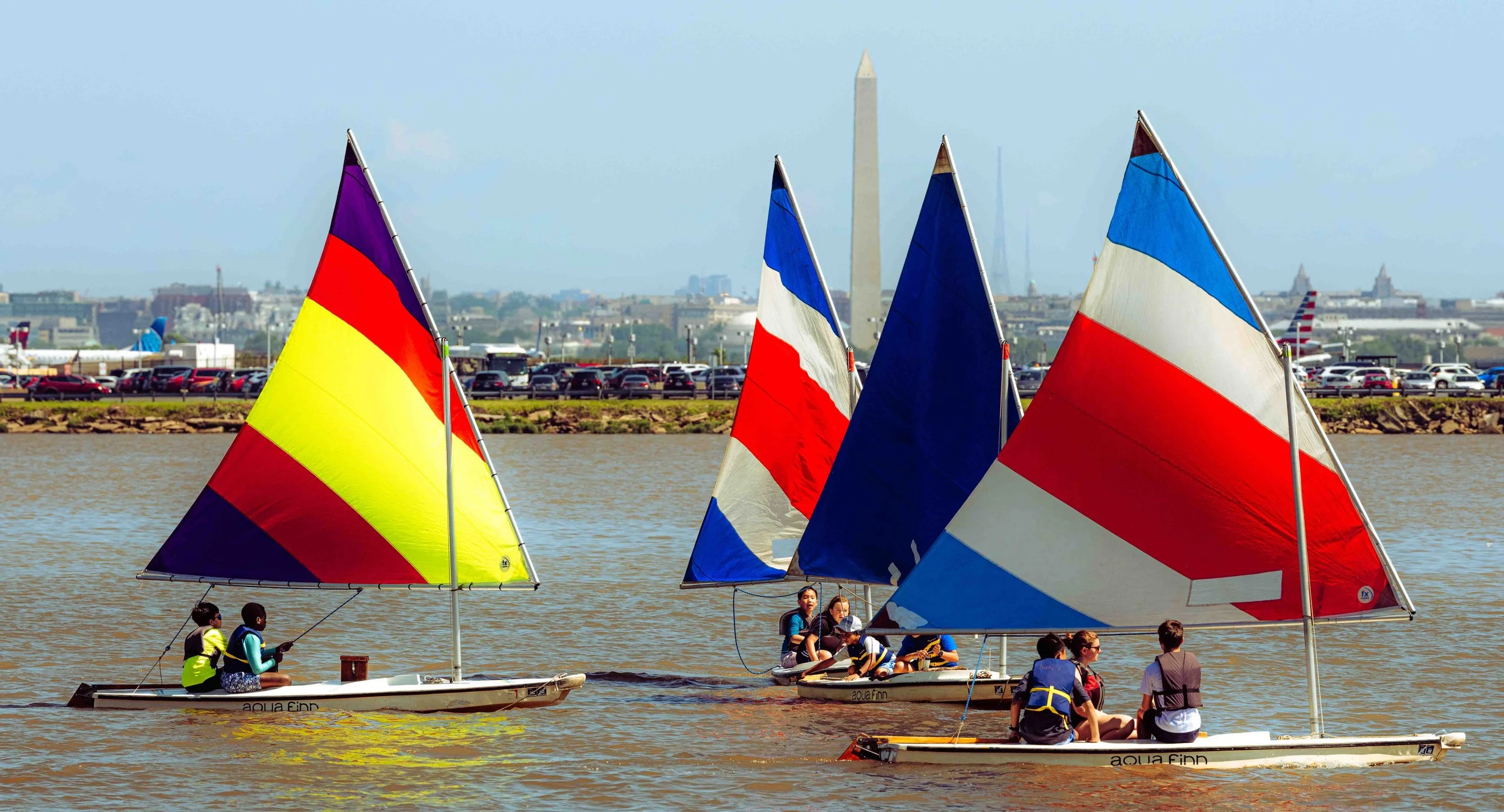 Student sailors participate in a hands-on lesson focused on navigation and sail trim.