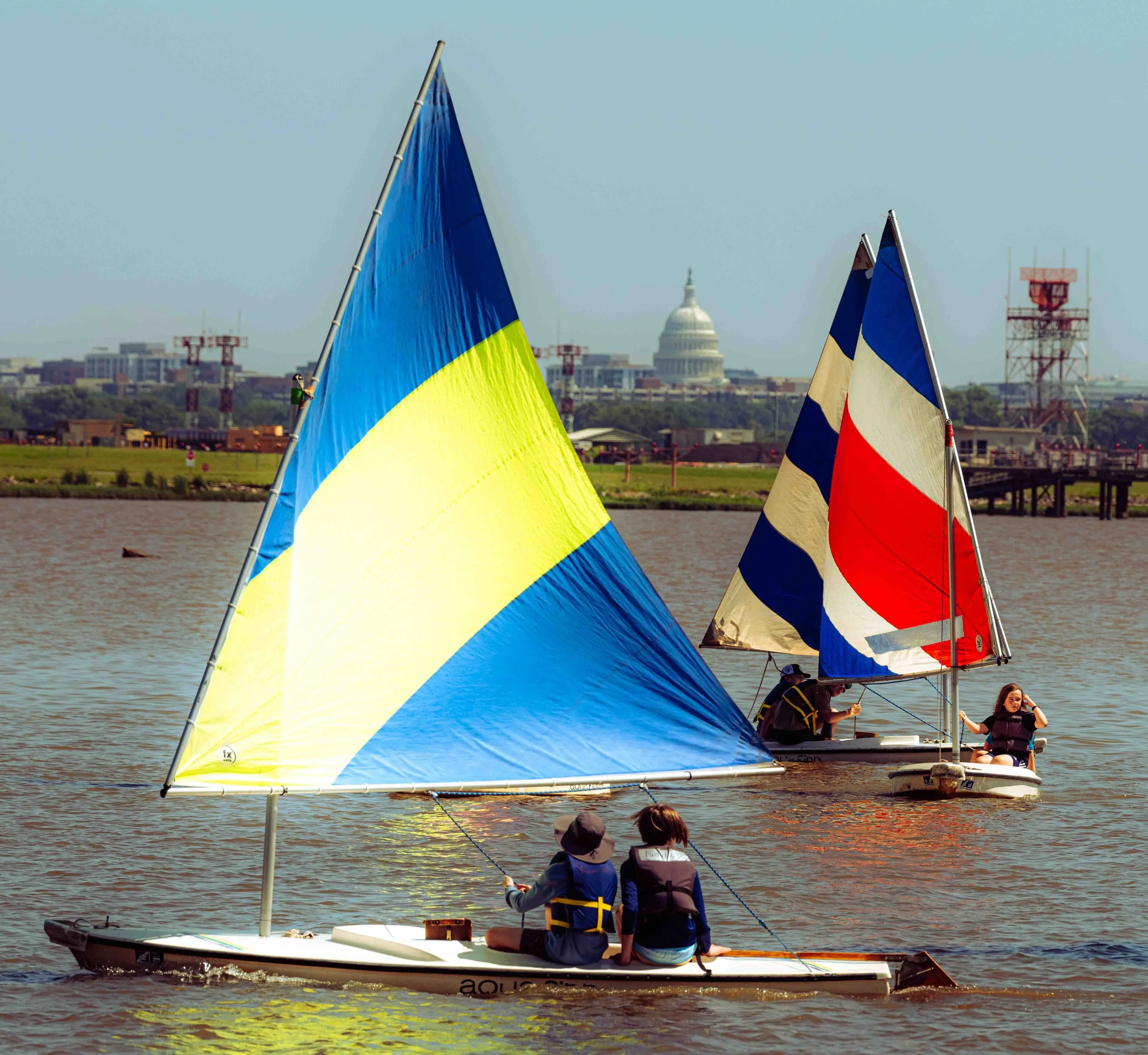 Sailing students work together to navigate changing wind conditions during on-water instruction.