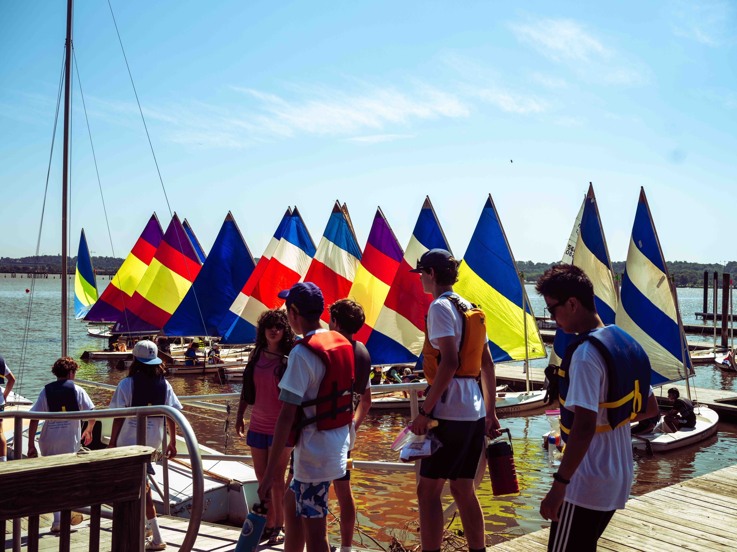 Students gather along the dock as instructors coordinate sailing activities and safety procedures.