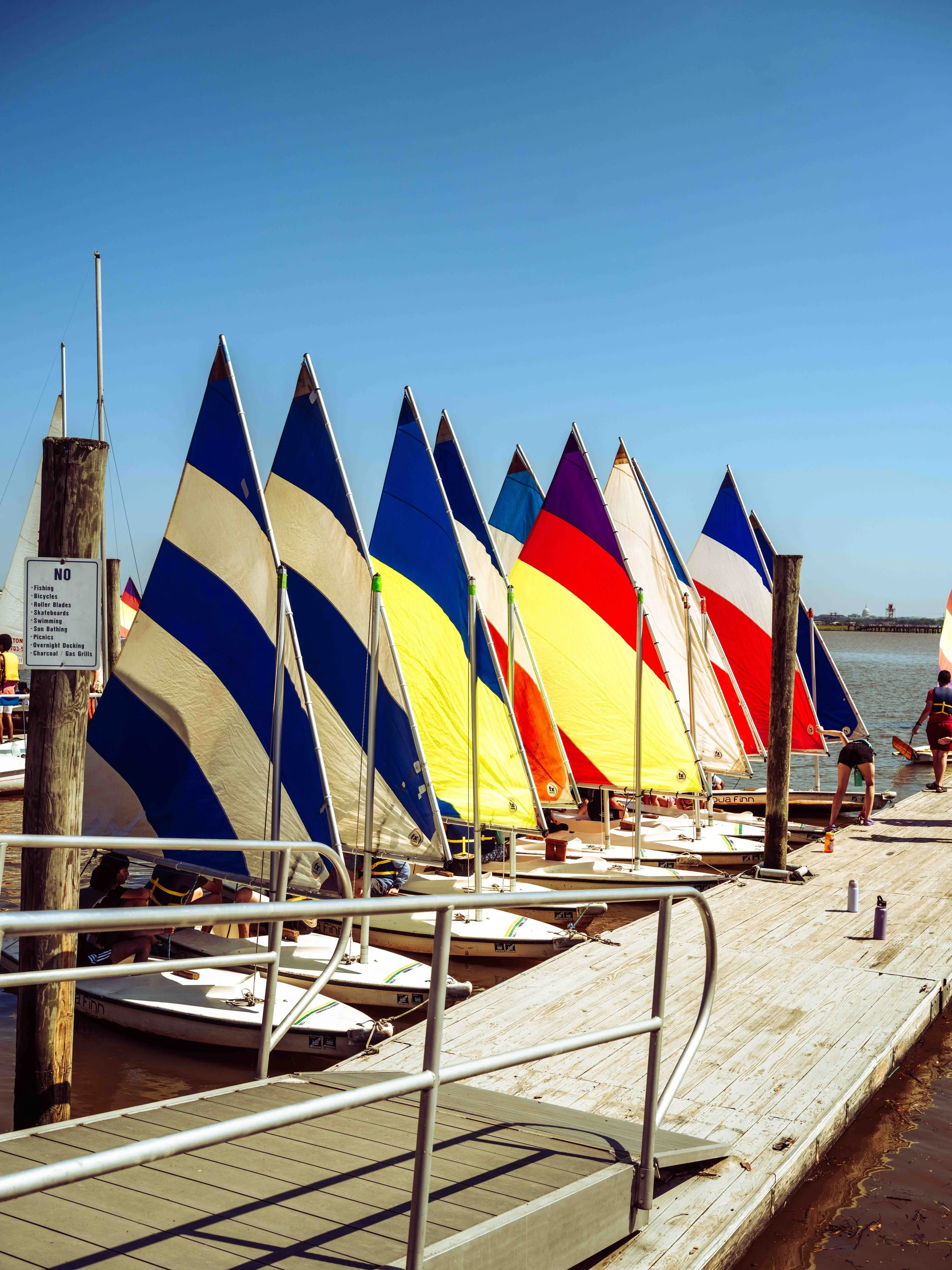 Rows of sailing dinghies line the dock before students launch onto the Potomac River.
