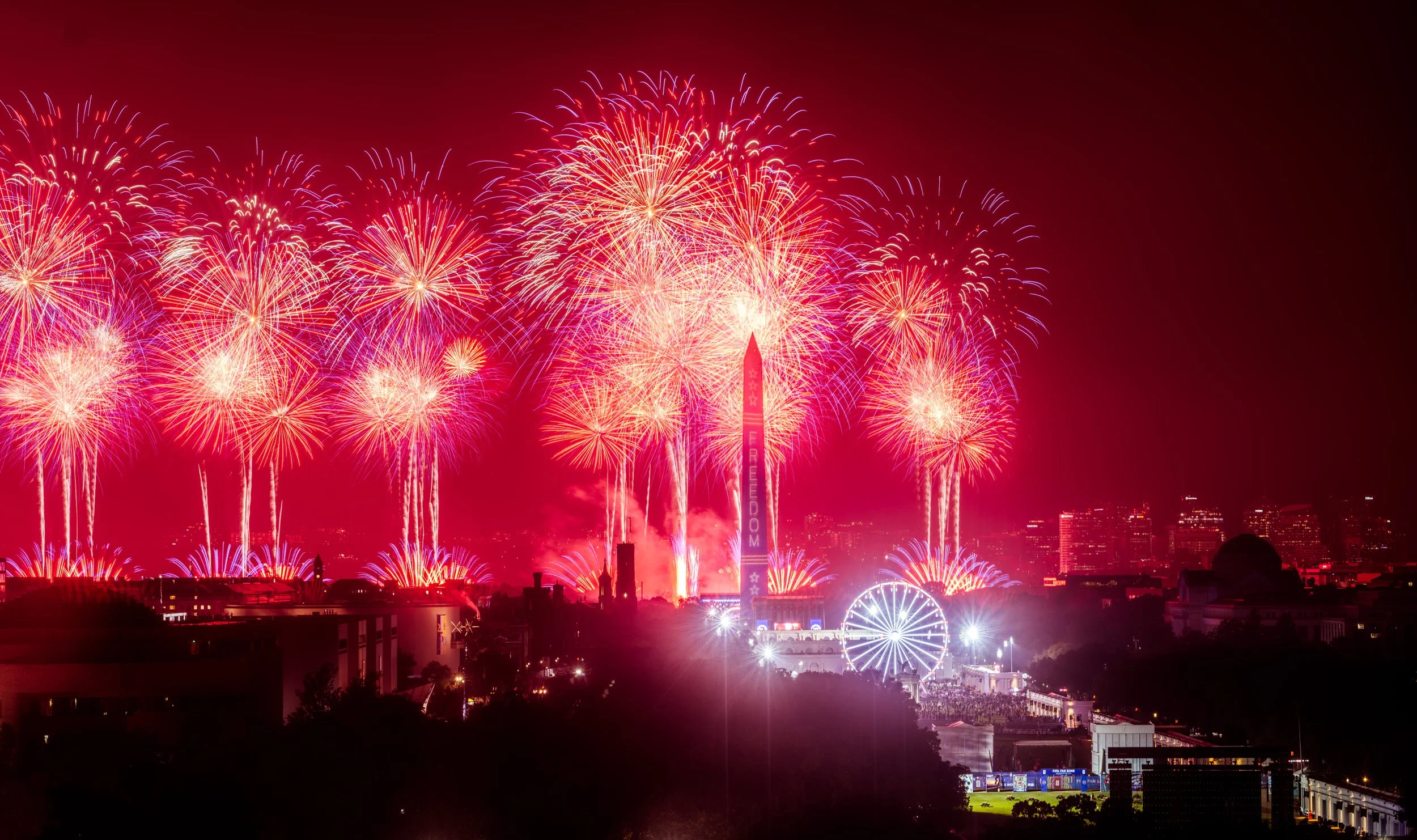 Massive synchronized fireworks bursts fill the night sky above the National Mall as thousands celebrate America's 250th anniversary.
