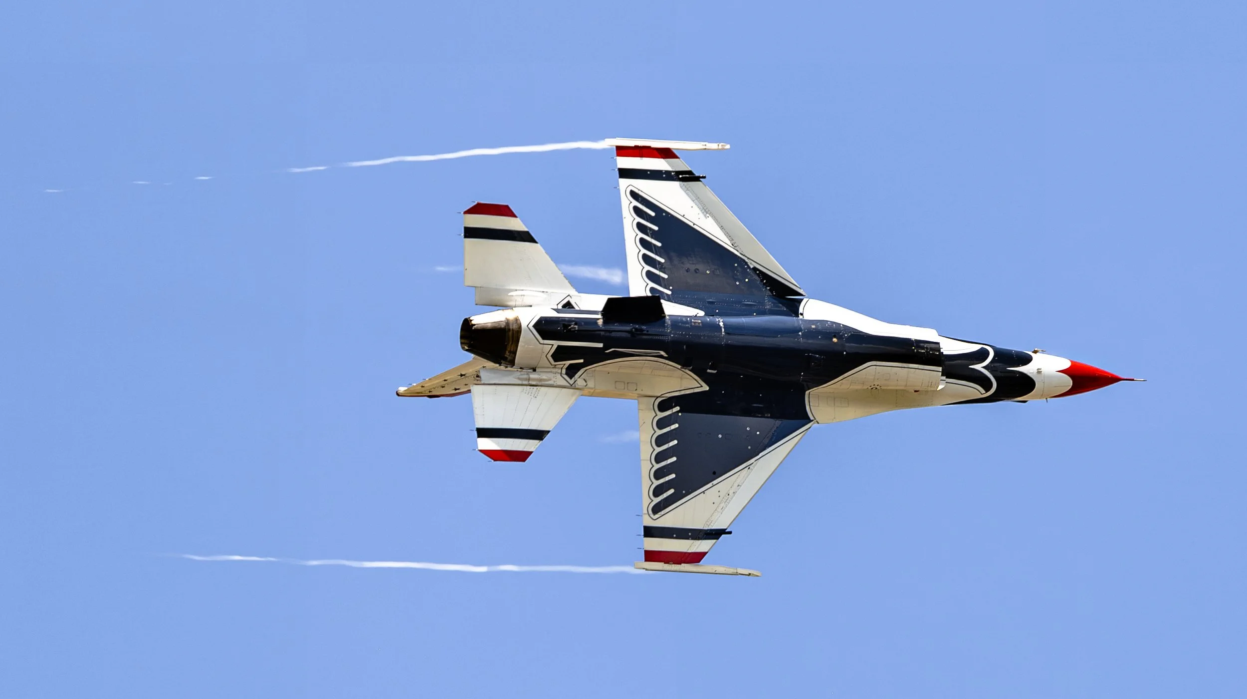 A solo Thunderbird performs a high-speed pass showcasing the precision and agility of the U.S. Air Force demonstration team.