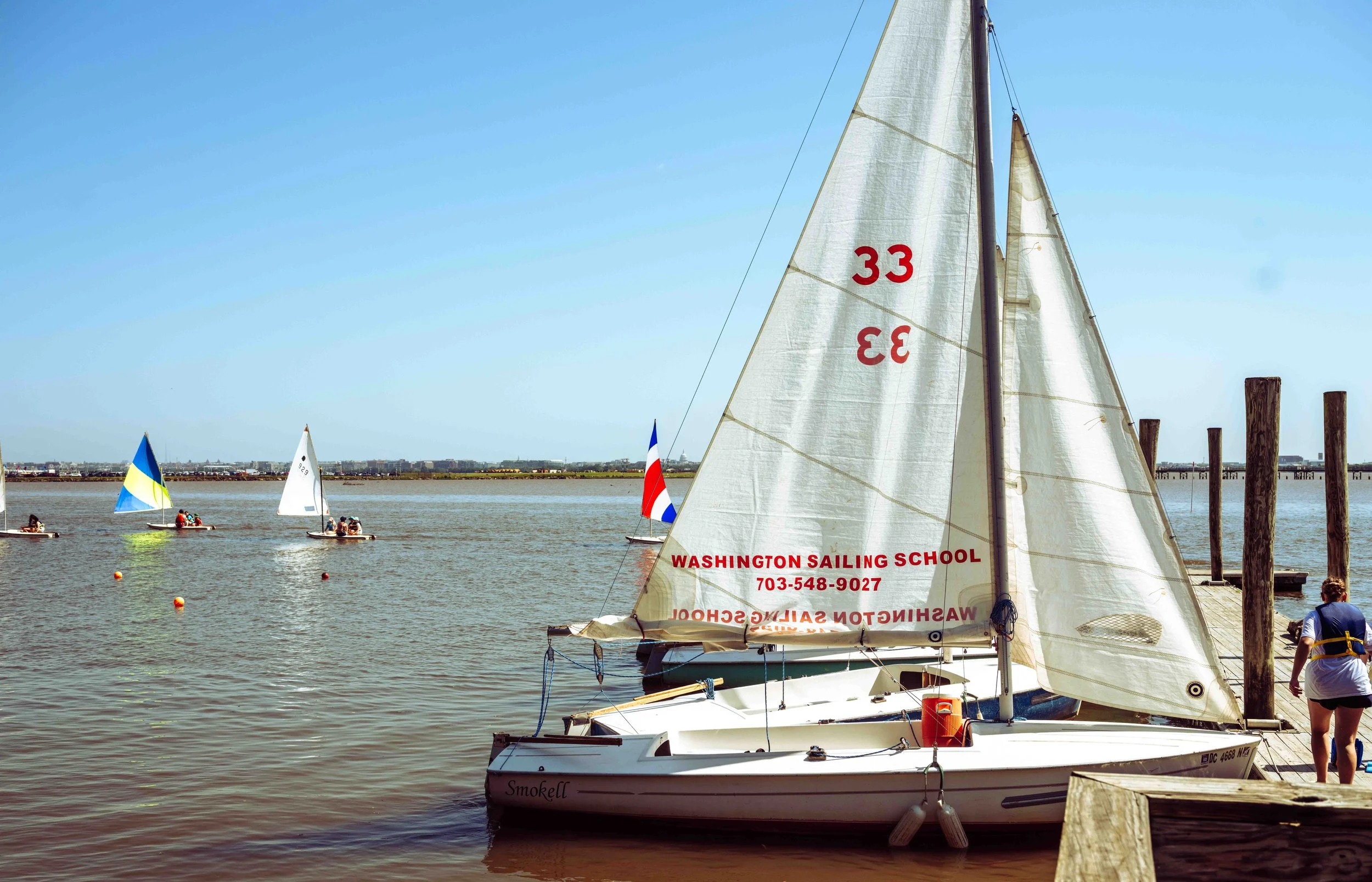 A fleet of training sailboats lines the dock following a day of instruction on the Potomac River.