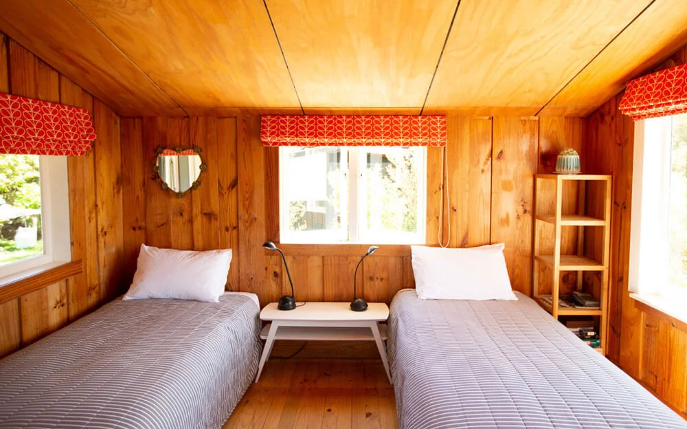 Two single beds with side table and wooden interior