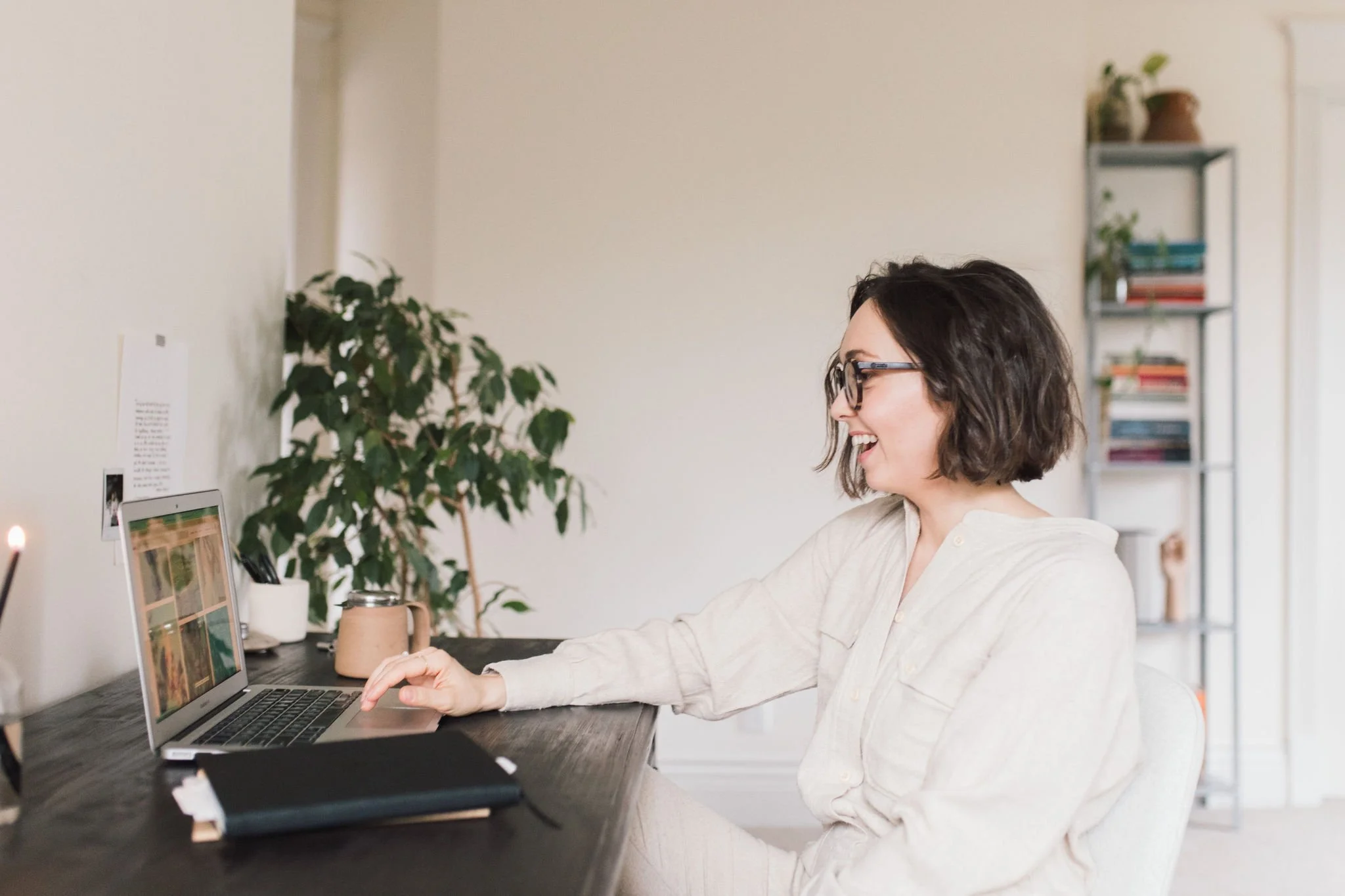 Kait at her laptop, appearing to meet with a client online, representing personalized 1:1 support in the Integrate package of the Growing with the Seasons workshop series.