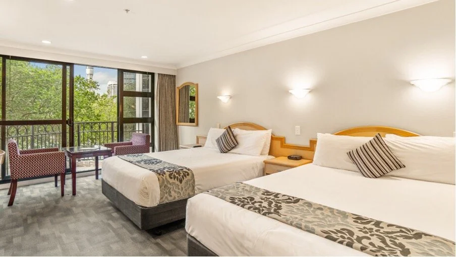 Double and single beds in a Deluxe Family Room at Parkside Hotel Apartments