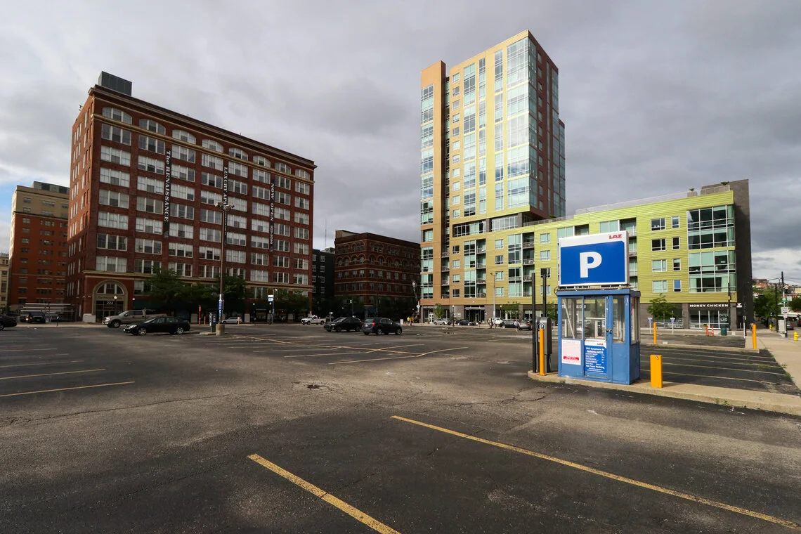 The rest of the block is still occupied by surface parking, just as it has been since the late 80s. In the background of this photograph is the Power Building (left), a former commercial building renovated into a luxury apartment complex known as "T…