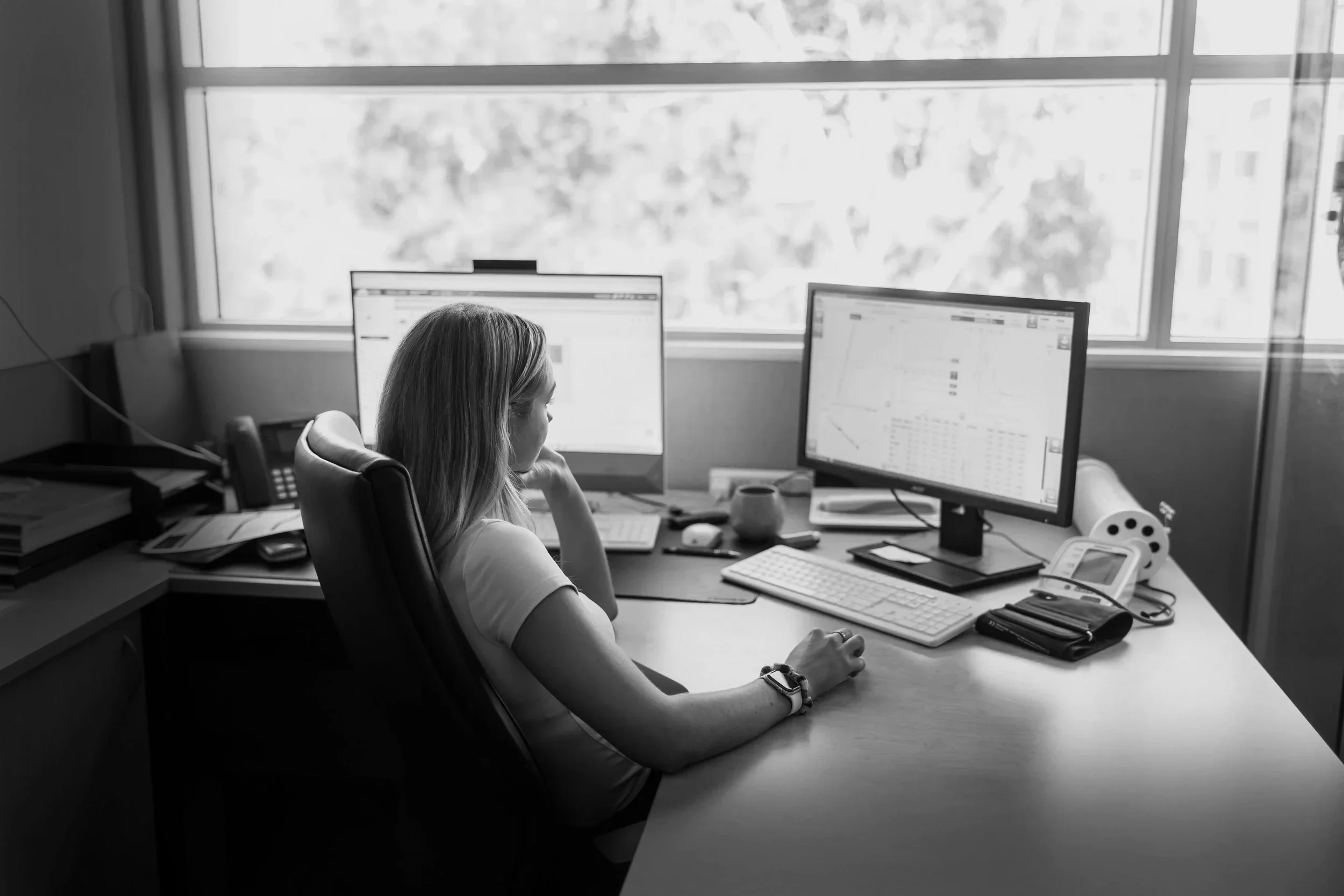 Somnocare female team member sitting at desk working on computer in the Somnocare Perth clinic.