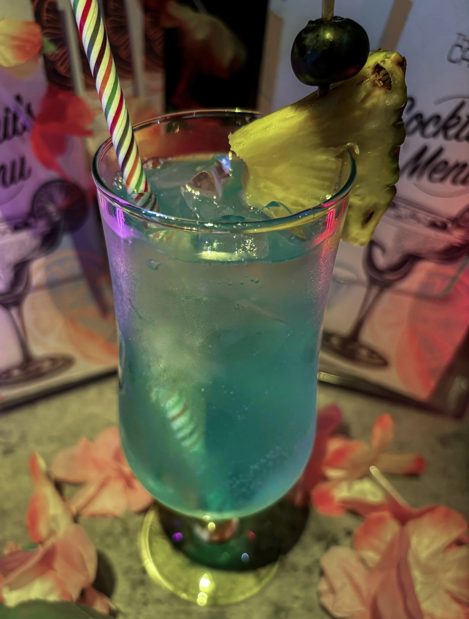 Blue Lagoon:

Vodka, Peach Schnapps, Lemon Juice, Blue Curaçao & Lemonade


Garnished with fresh pineapple and blueberries, this vibrant cocktail is fruity, refreshing and bursting with tropical flavour. A colourful classic that's as good to look at 