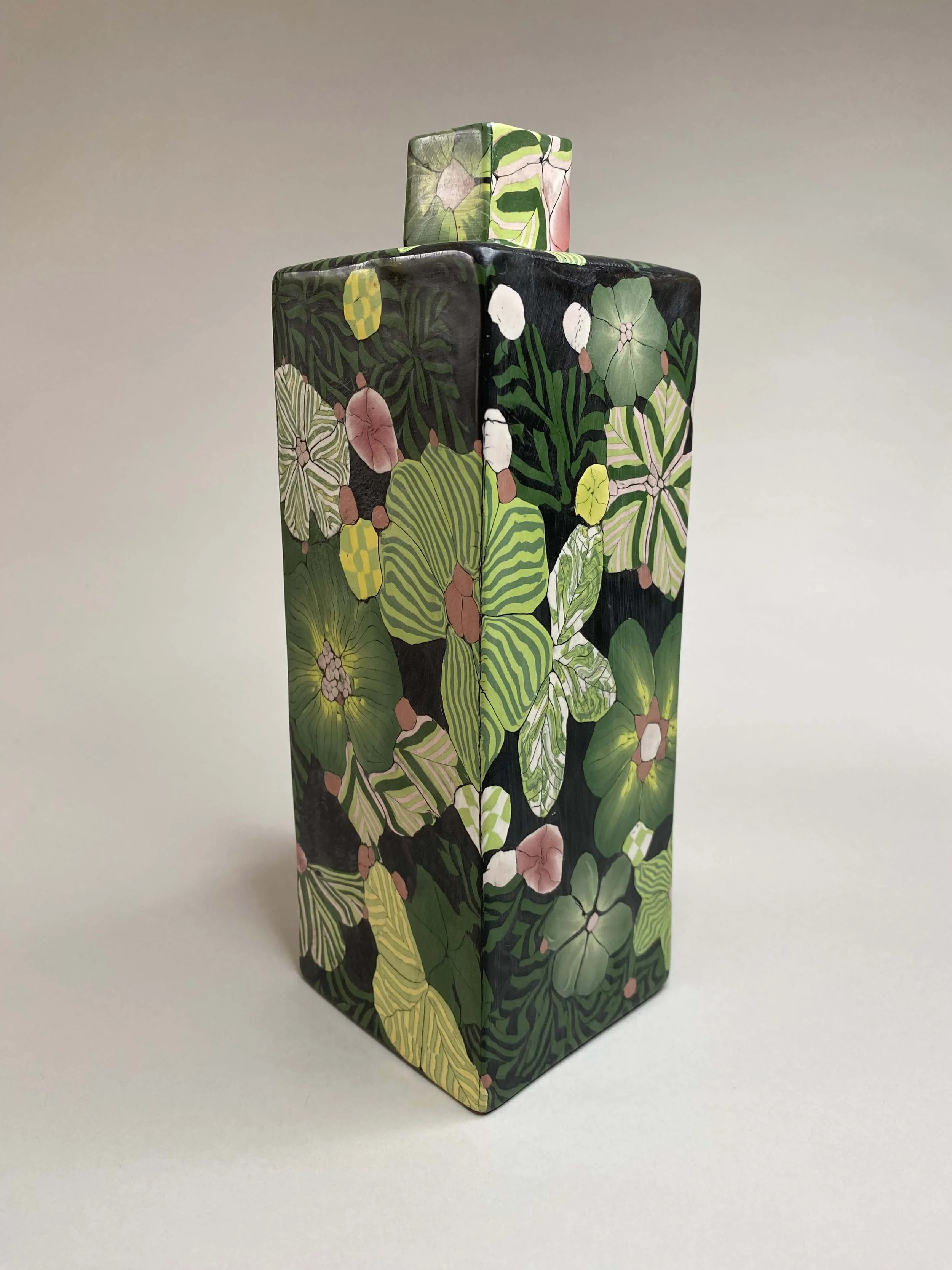 Green floral bottle black background