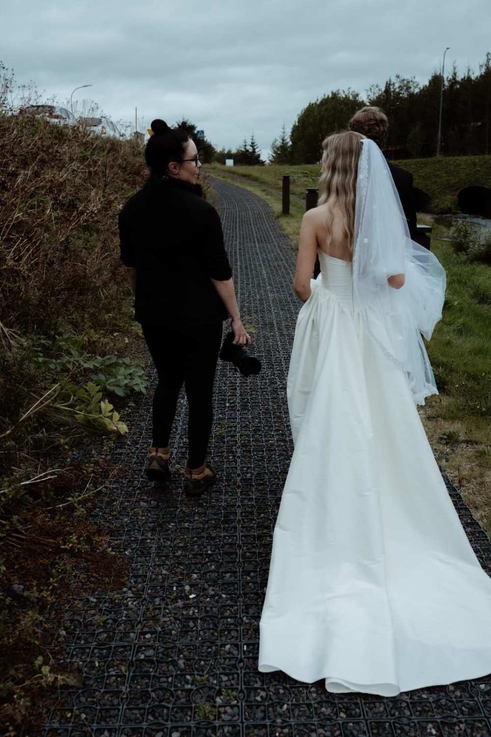 Iceland elopement photographer Lisa walks beside a bride while guiding her during her elopement day.