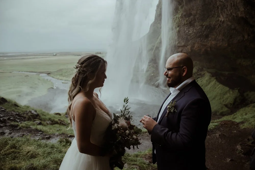 Couple standing in front of Seljalandsfoss during their South Iceland elopement.