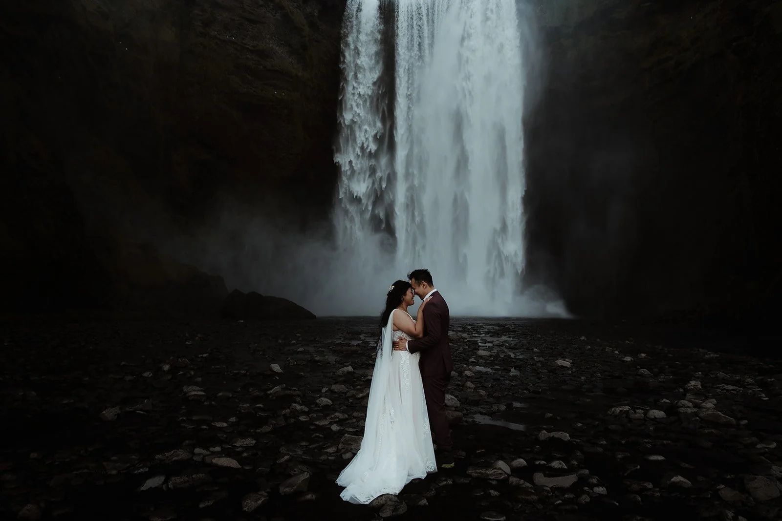 bride and groom getting married in front of Skogafoss waterfall