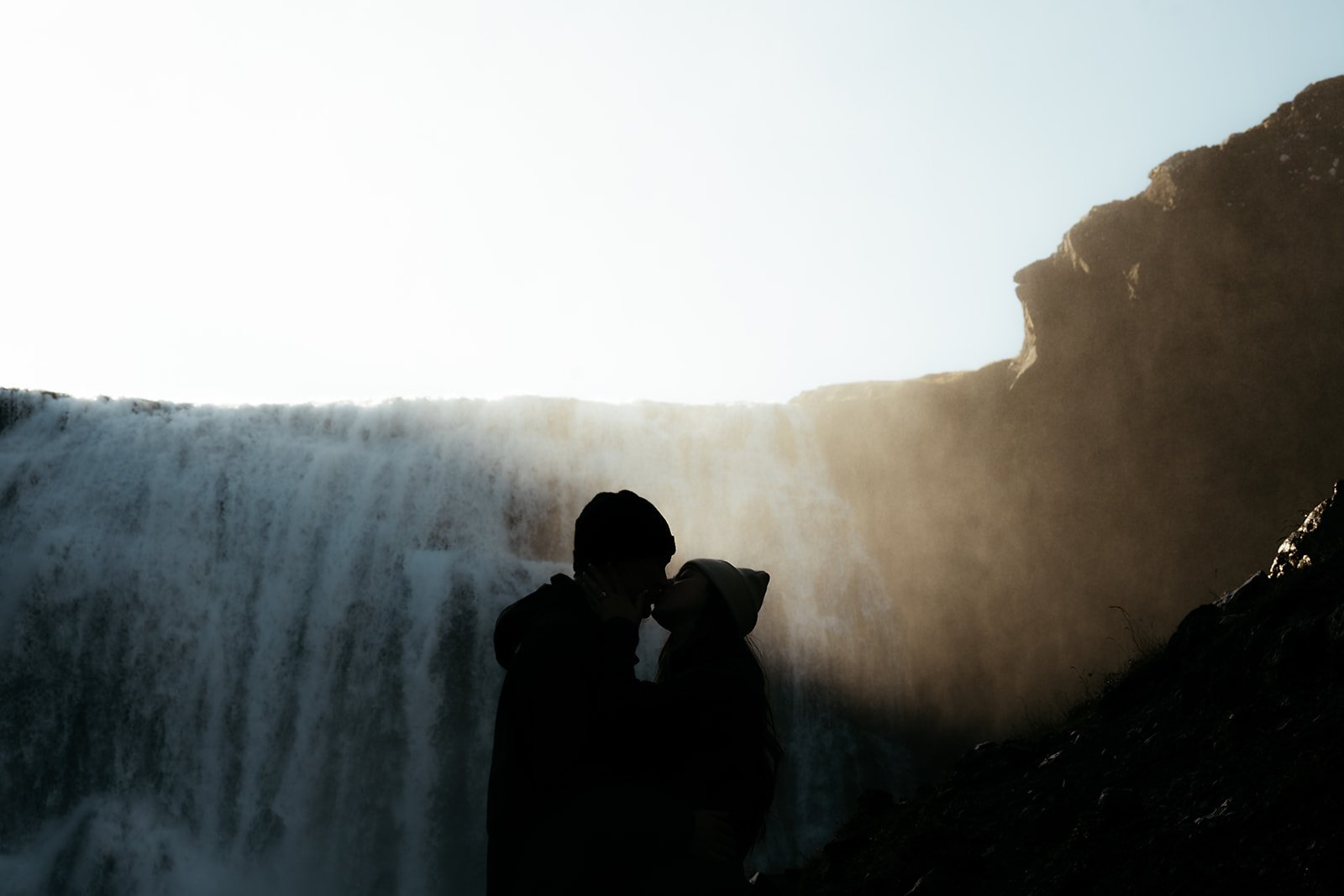 Couple celebrating their engagement in the Icelandic countryside at Þórufoss waterfall