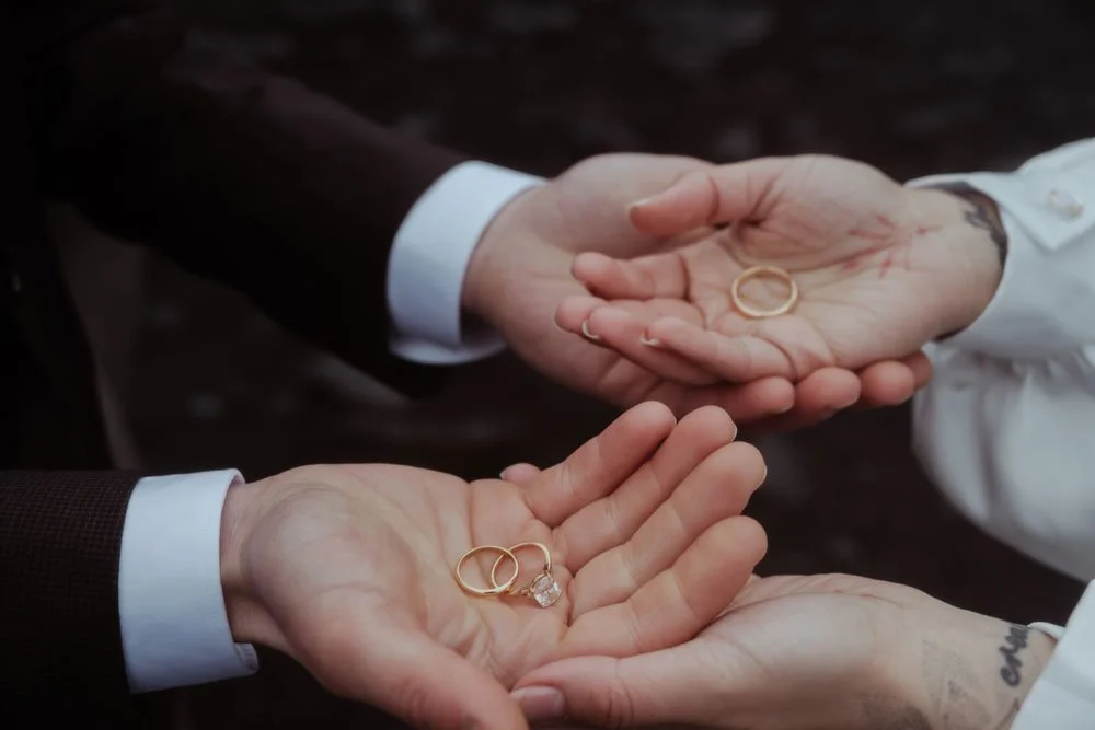 couple exchanging rings beneath Iceland waterfall