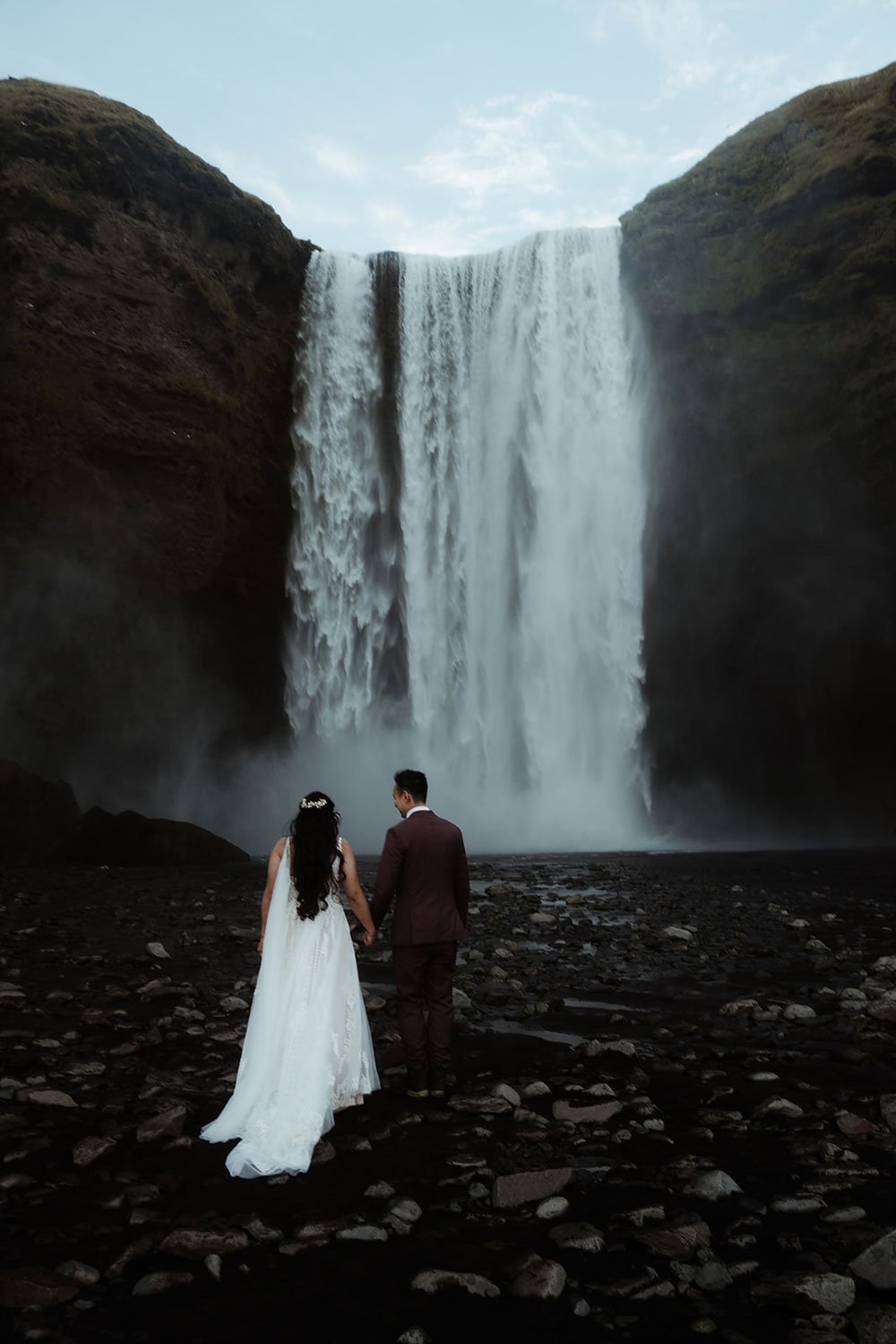 bride and groom getting married in front of Skogafoss waterfall