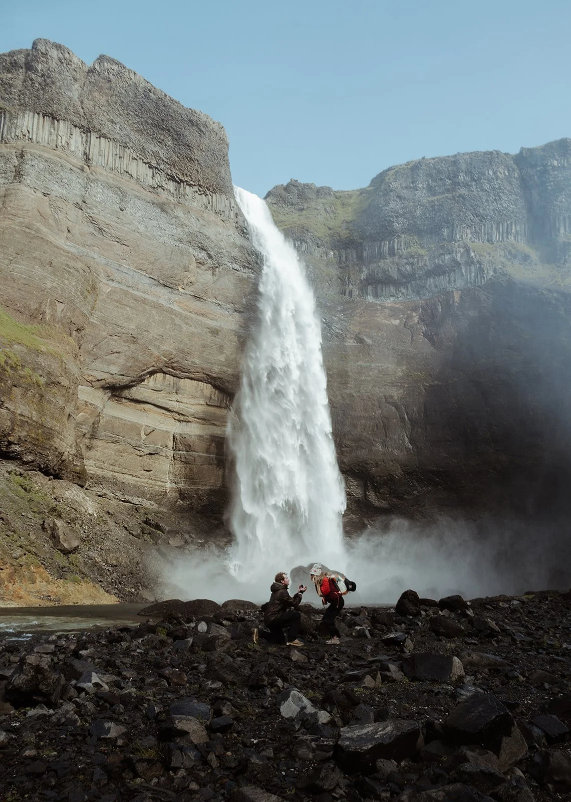 surprise Iceland hiking proposal beside a dramatic waterfall and canyon