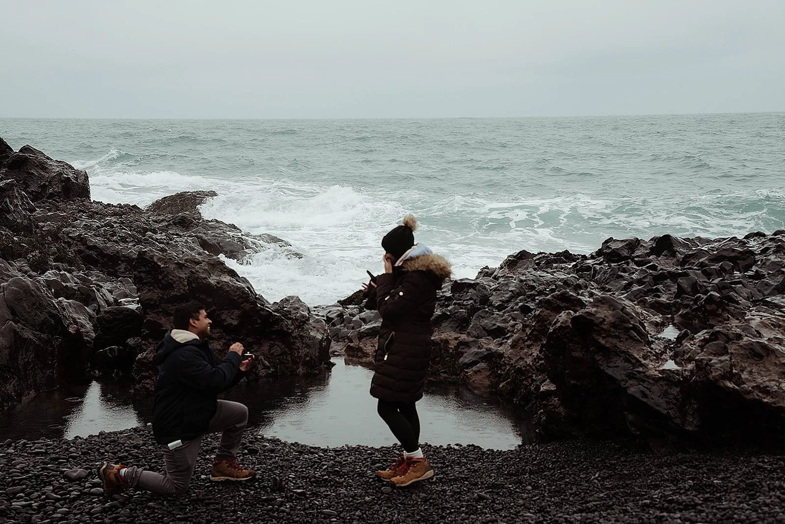 Couple celebrating their engagement on Djúpalónssandur black pebble beach in Snæfellsnes Iceland