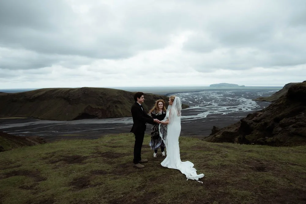 A couple exchanges vows during an adventurous Iceland Highlands elopement overlooking a vast river valley.