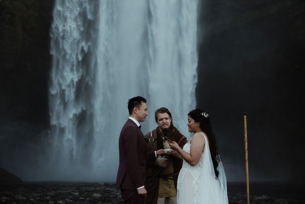 bride and groom getting married in front of Skogafoss waterfall