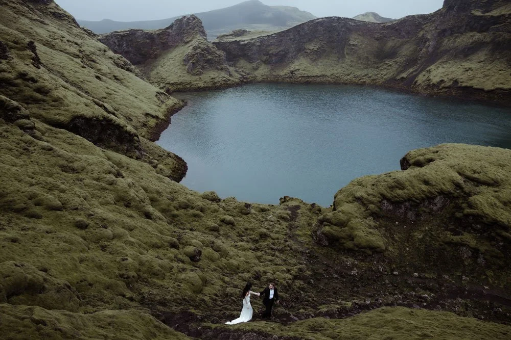 bride and groom walking through Iceland lava fields