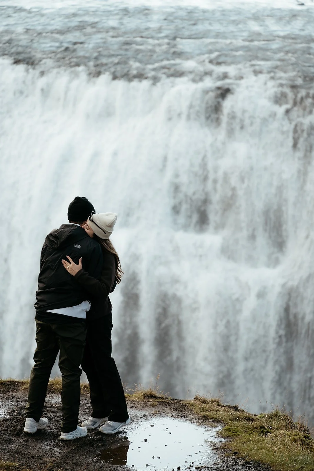 Tyler and Madison embracing after their surprise waterfall proposal near Reykjavík