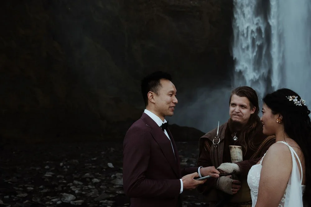 bride and groom getting married in front of Skogafoss waterfall