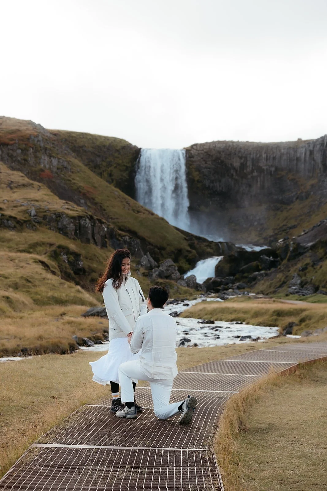 Couple celebrating their engagement at Svöðufoss waterfall on the Snæfellsnes Peninsula