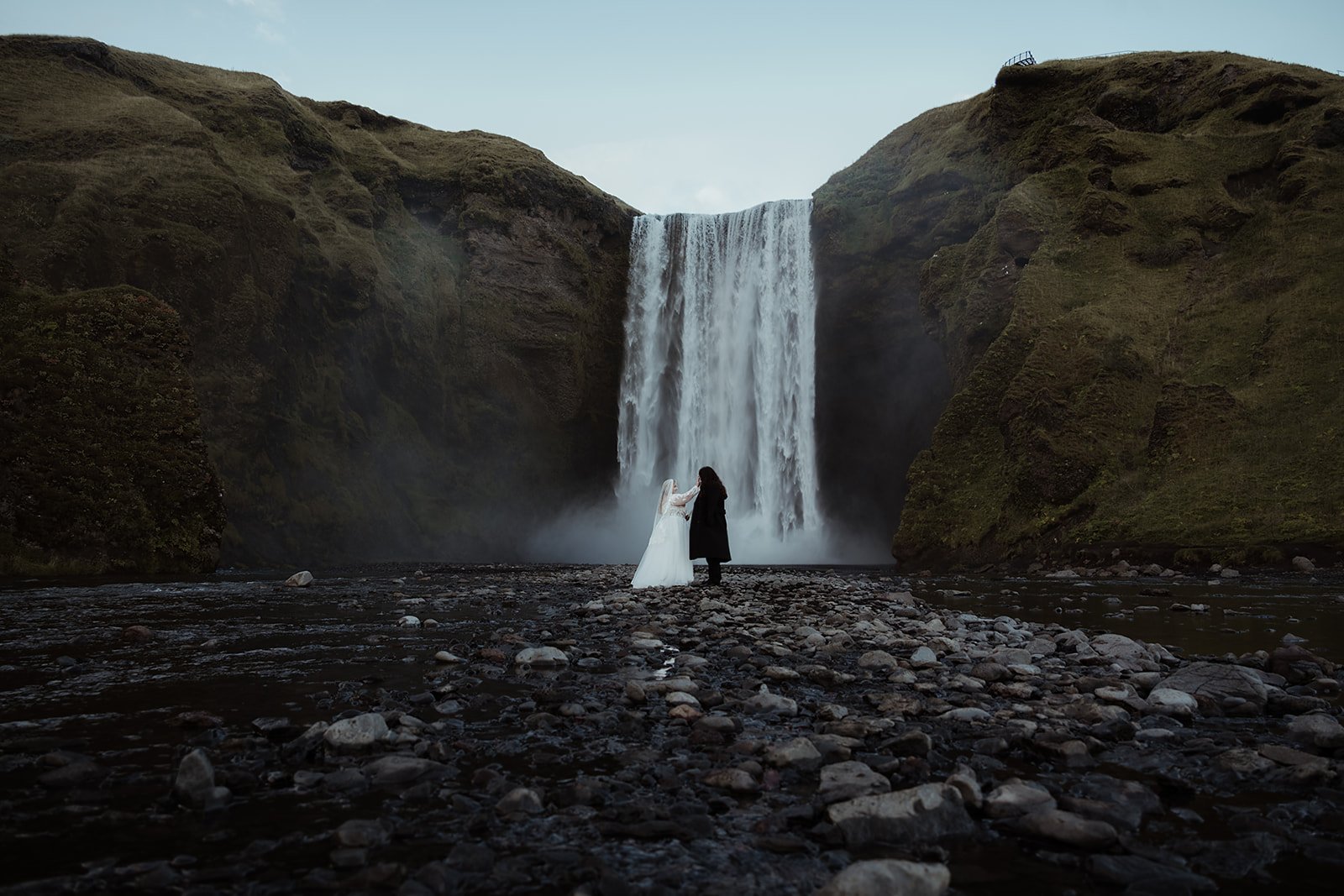 Hanna and Wyatt exchanging private vows in front of Skógafoss waterfall in Iceland