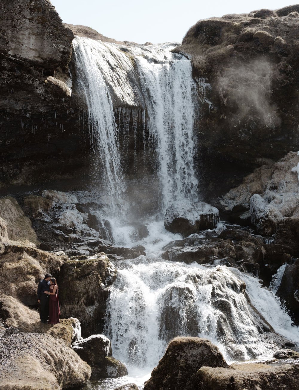 couple celebrating engagement after Iceland waterfall proposal