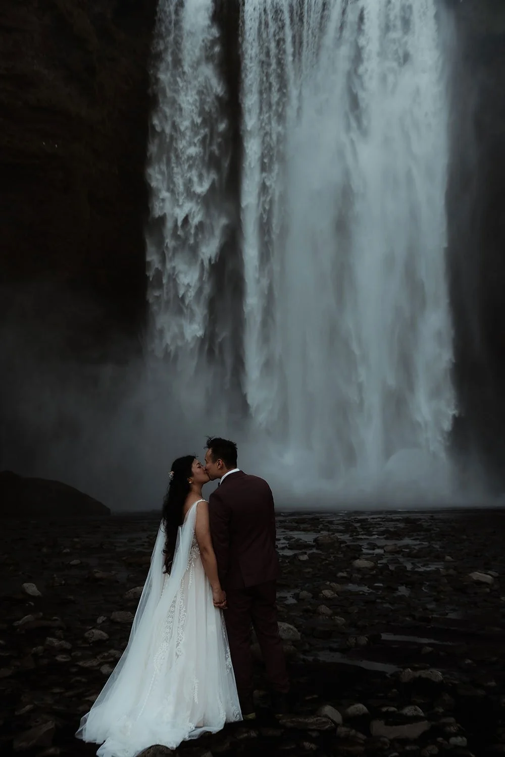bride and groom getting married in front of Skogafoss waterfall