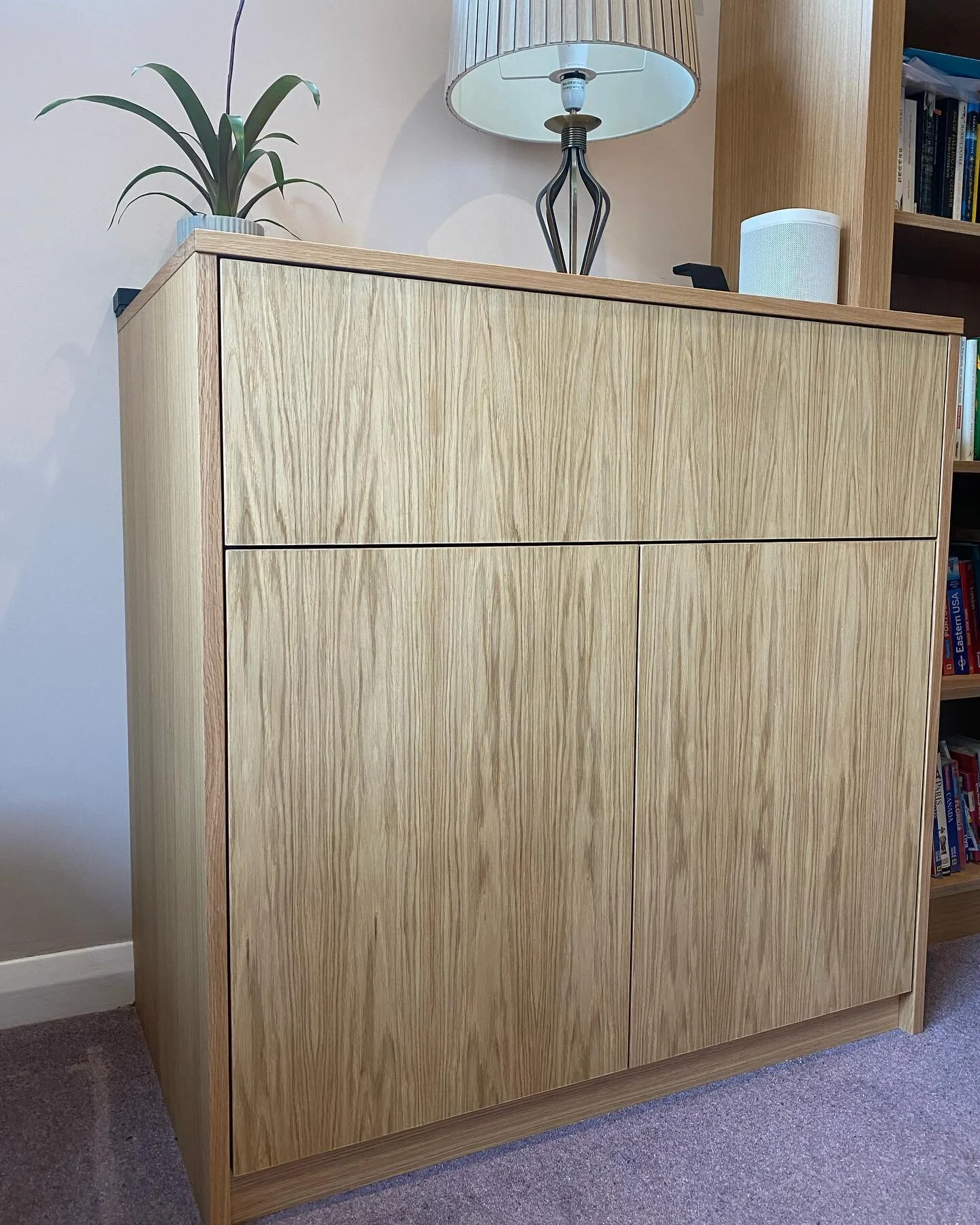 This real Oak veneer cupboard and bookshelf maximised the corner space in this office, by stretching the bookshelf  across two walls and a cupboard underneath the window, with a grain matched drawer front and doors. The veneer was finished with a cle