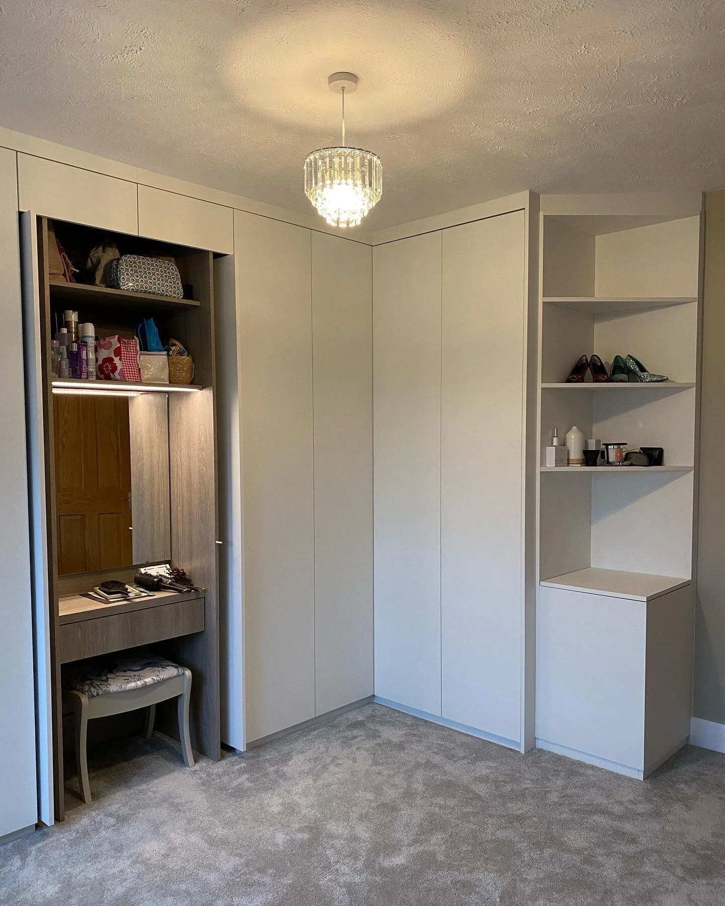 This huge L-shaped wardrobe used all the space wisely, with open shelving at the end with a laundry bin at the bottom (photo 3). Behind pocket sliding doors was a dressing table with hidden storage behind the mirror (shown at the end of the video). W