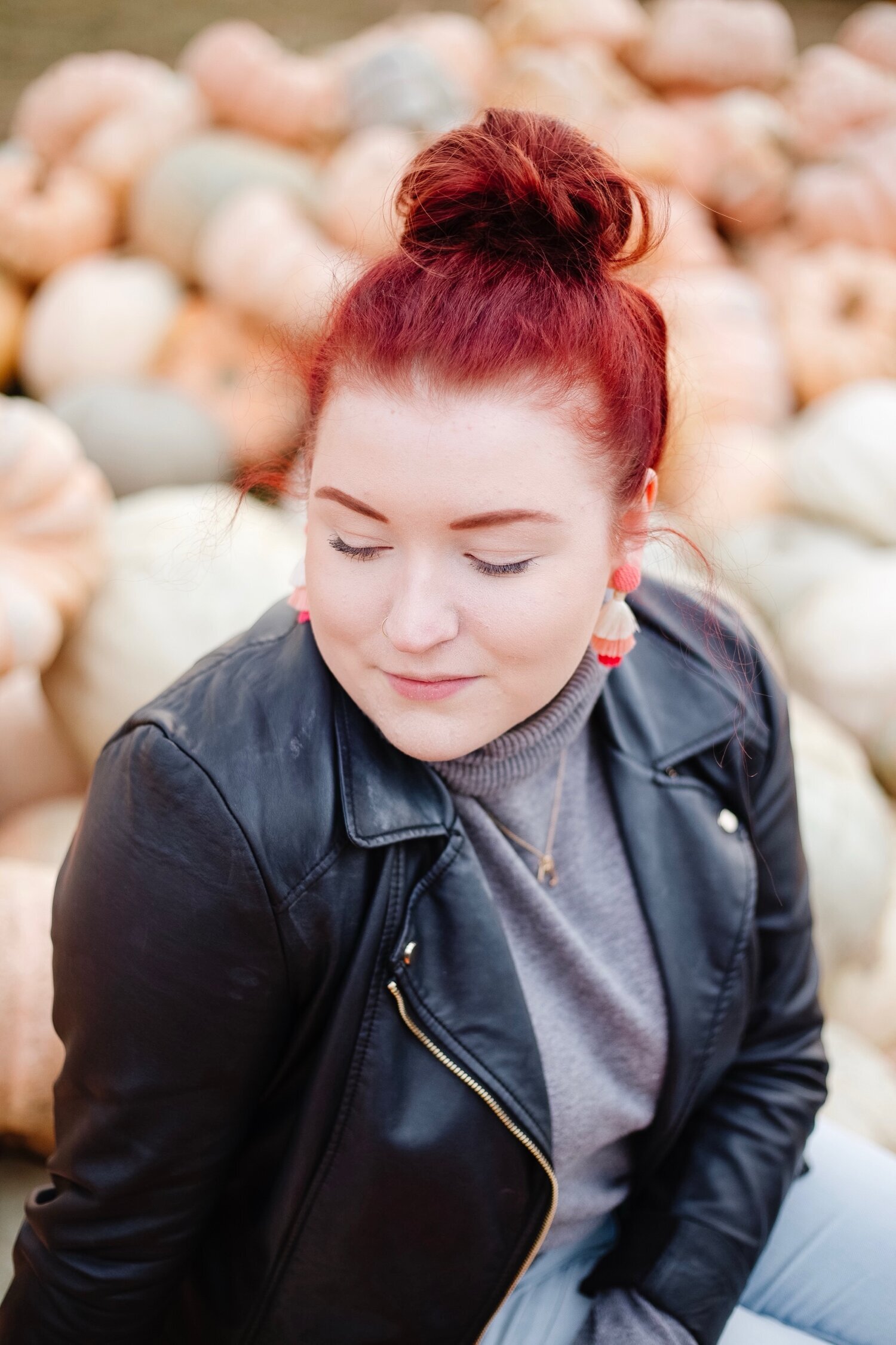 Close up of girl sitting on pumpkins.
