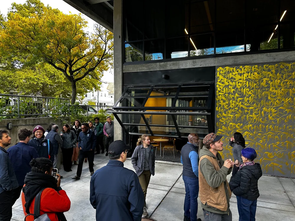 The commercial spaces feature large folding glass facades.