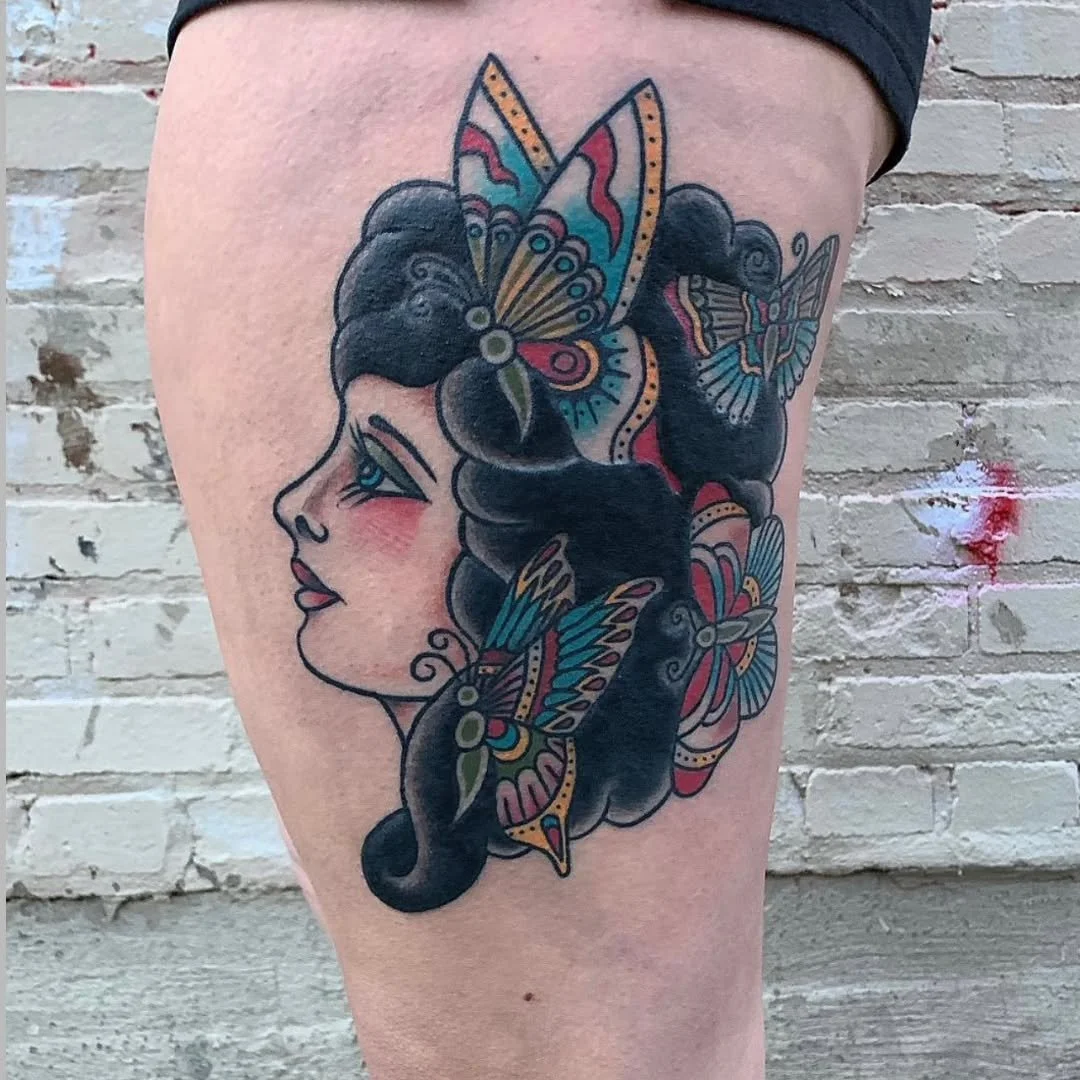 Zack recently completed this stunning piece, blending American Traditional and Neo-Traditional styles into a gorgeous side-profile. This raven-haired woman features vibrant, colorful butterflies that add a perfect pop of life to the design. The bold 
