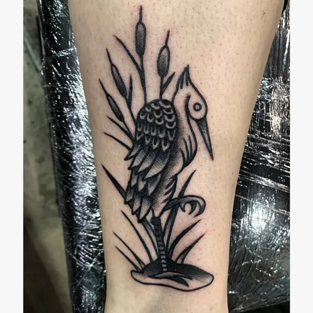 Zack recently completed this striking Traditional/Neo-Traditional tattoo of a crane, standing gracefully on a patch of marshland. The design features detailed cattails poking up in the background to create a beautiful sense of depth. The bold linewor