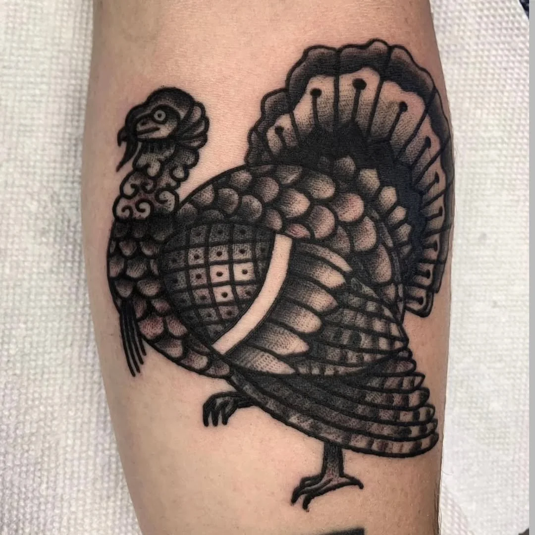 Zack tattooed this incredible traditional blackwork turkey, featuring heavy textures and bold patterns. It features detailed fanning of the tail feathers and intricate stippling on the wings, perfectly showcasing the power of high-contrast traditiona