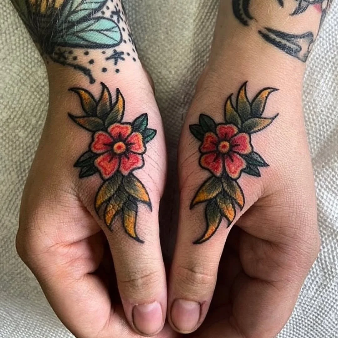 Zack tattooed this beautiful, symmetrical pair of traditional styled flowers, placed perfectly on the base of the thumbs. Featuring rich red petals and vibrant gold-tipped leaves.

Whether you want a striking placement like this, a custom floral proj