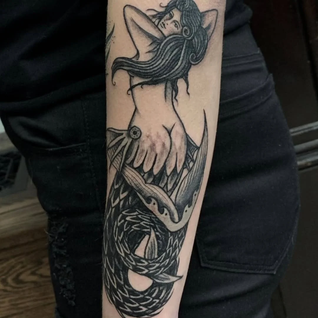 Shoutout to this incredible tattoo! Zack absolutely crushed this bold traditional blackwork mermaid, depicted playfully looking over her shoulder and tossing back her long hair. The deep contrast, detailed scaling, and clean linework make this aquati