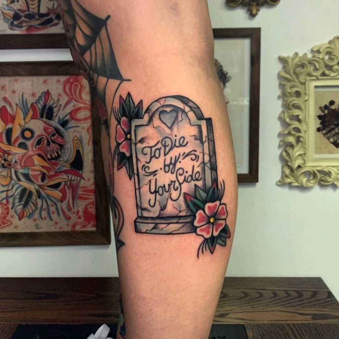 Zack zapped this incredibly detailed headstone tattoo, featuring the touching epitaph "To Die by Your Side" scripted across the front. This traditional piece is framed with textured cracks, a carved heart at the top, and beautifully shaded 
