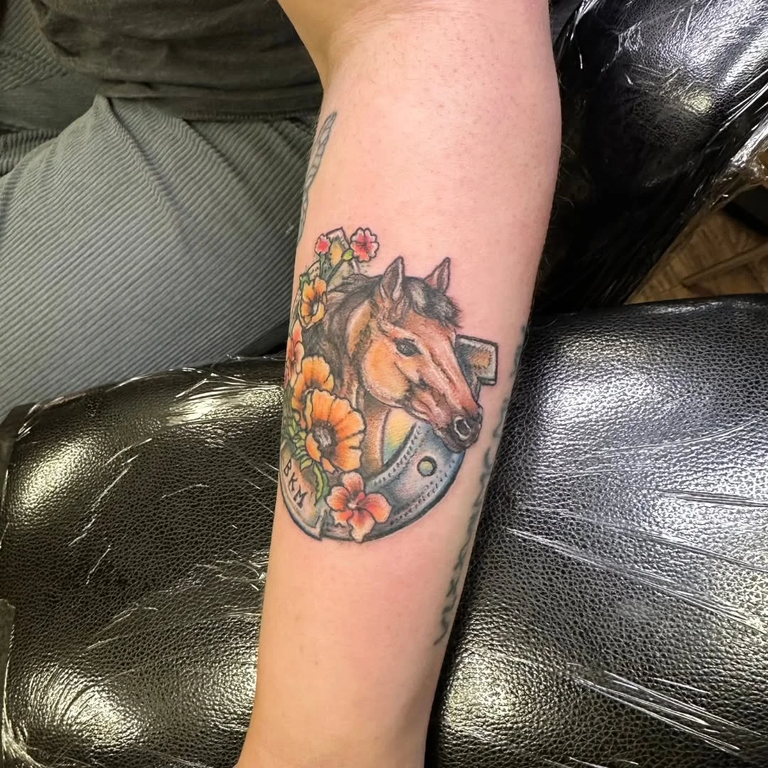 Kelly inked this lovely horse memorial on Alexa back in April, it's a gorgeous horse with deep chestnut hair, set inside a classic iron horseshoe. The majestic mammal is surrounded by flowers saturated with bright, rich color, creating a meaningful p