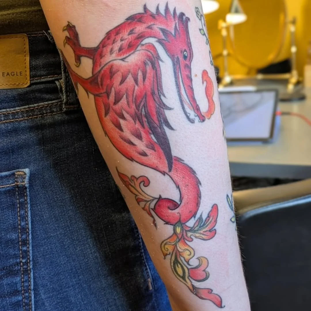 This super fun dragon tattoo by Rachel (his name is Phillipe!) came out great on Izzy! Clean shading on the reds, great details in the black scales, and just the right amount of smoke emanating from the mouth give this lovely piece so much character.