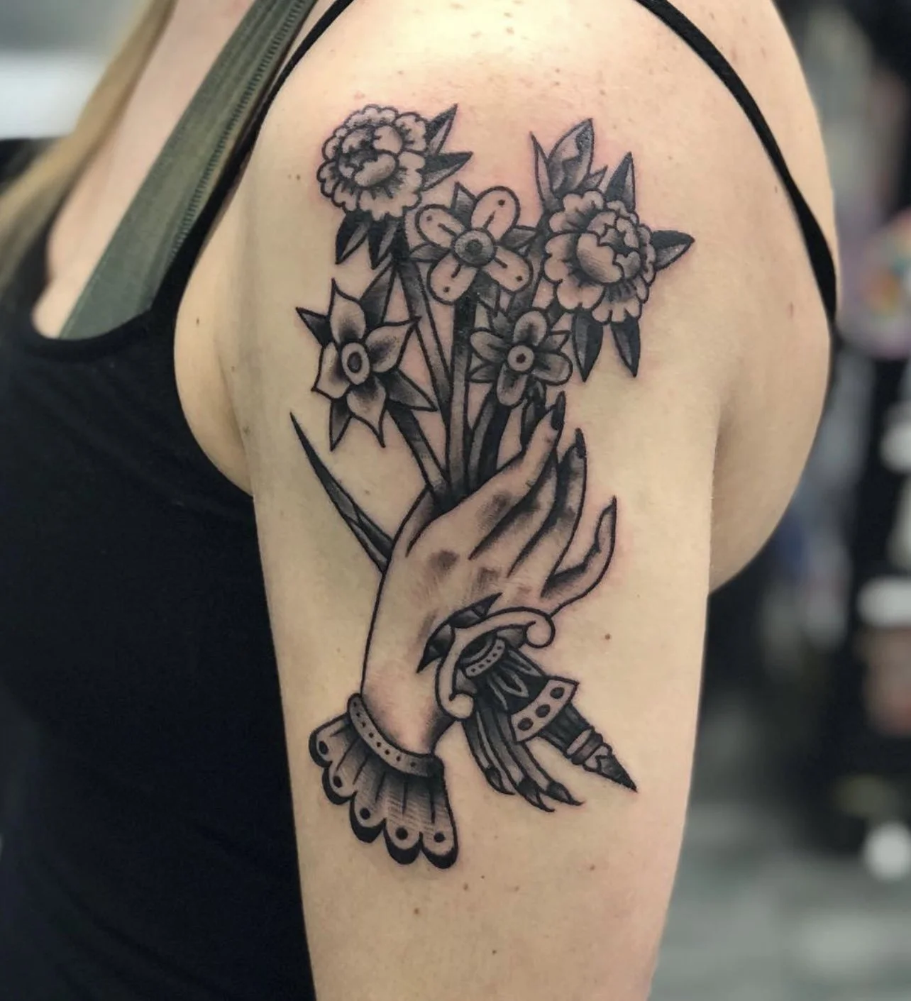 Traditional Blackwork hand holding a bouqet