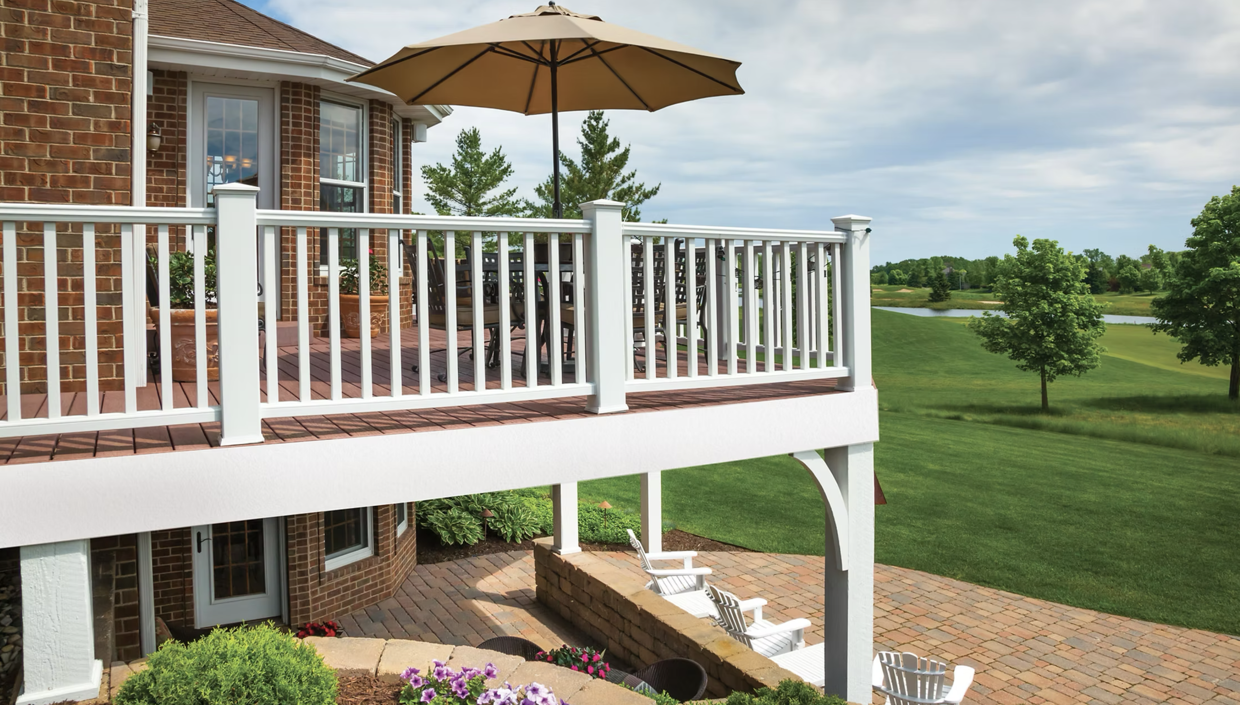Elevated outdoor deck featuring DexEra composite decking with white railing overlooking a landscaped backyard.