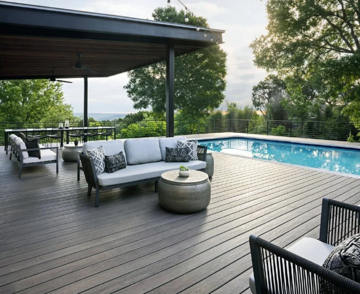 DexEra composite decking installed around a modern outdoor pool with covered patio and comfortable seating