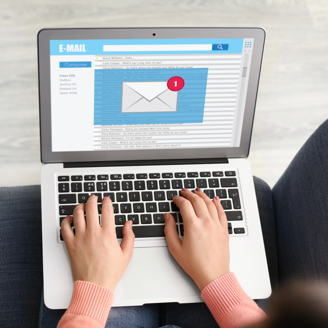 Person using a laptop to check emails, with an email notification on the screen.